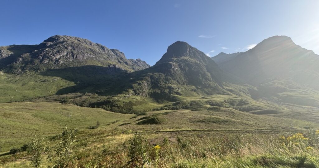 Three mountain peaks above a green valley