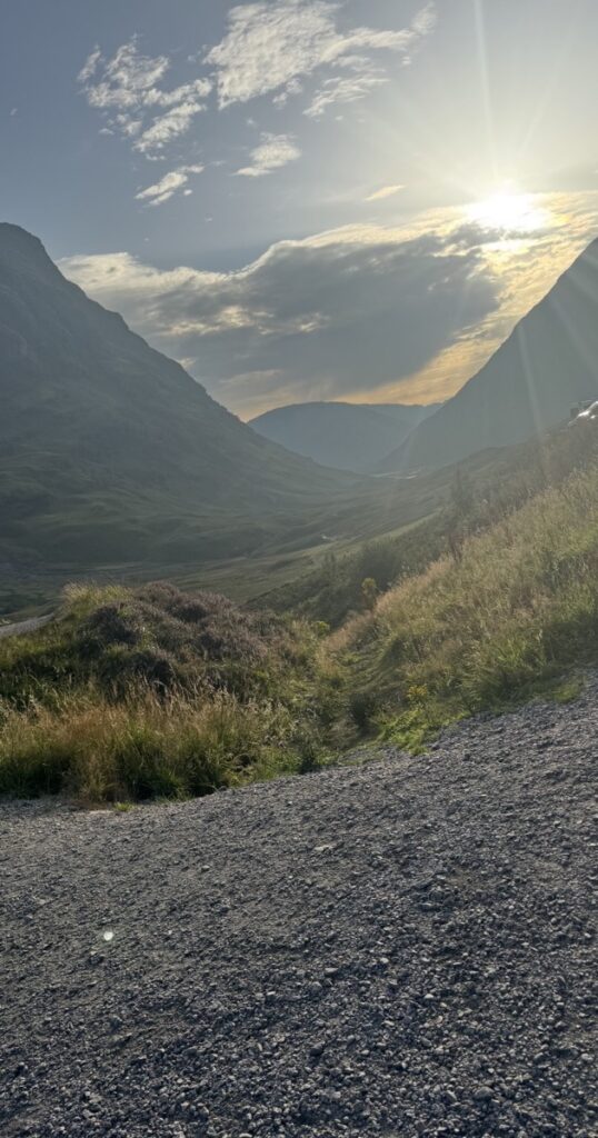 A trail descending into a mountain valley at sunset
